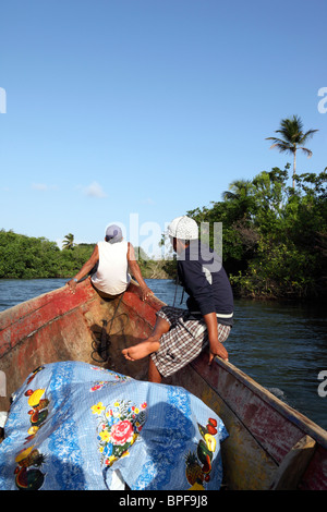 Kuna-einheimische Jungen sitzen auf Bug eines traditionellen Holzkanus auf dem Rio Grande de Carti, Comarca de San Blas, Panama Stockfoto