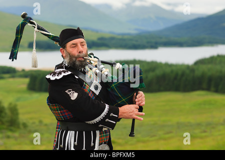 Dudelsack-Spieler auf den schottischen Highlands Stockfoto