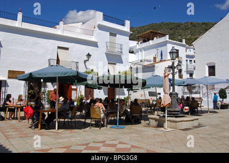 Menschen an Café-Tischen in der Stadt (Plaza De La Iglesia), Frigiliana Costa del Sol, Provinz Malaga, Andalusien, Spanien, Europa. Stockfoto