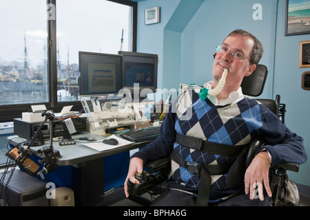 Geschäftsmann mit Duchenne-Muskeldystrophie mit einem Atem-Ventilator in einem Büro Stockfoto