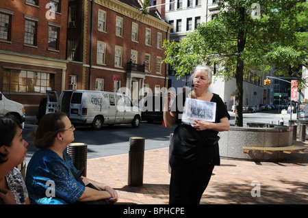 Marie Beirne von Wall Street geht im Gespräch mit einer Reisegruppe über Fraunces Tavern an der Pearl Street in Lower Manhattan. Stockfoto