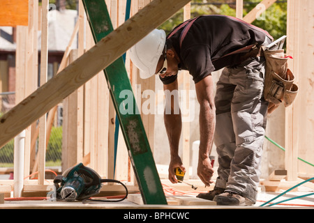 Zimmermann, die Messung mit einem Maßband auf einer Baustelle Stockfoto