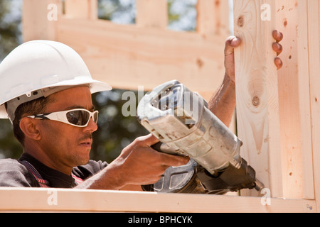 Tischler mit einem Bolzenschußgerät auf einer Baustelle Stockfoto