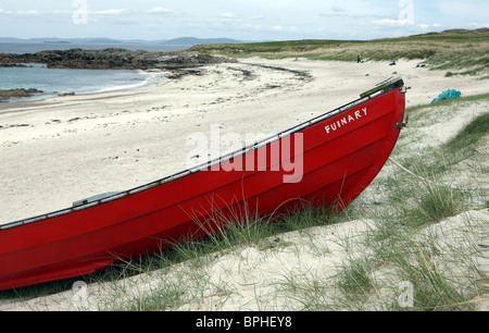 Rotes Boot an einem Sandstrand auf der Insel Iona Stockfoto