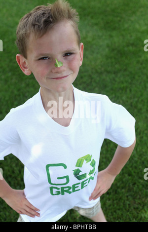 lächelnde junge stehend & tragen mit "grün"-t-Shirt Stockfoto