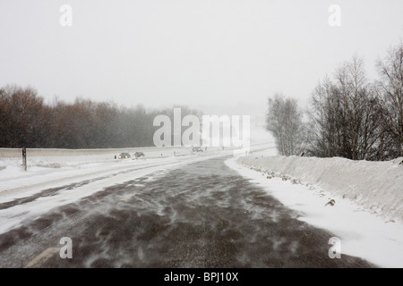 Schwedische Autobahn (E4) bei einem windigen, verschneiten Tag. Stockfoto