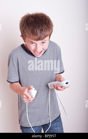 Ein MODEL Release Bild eines 10 Jahre alten Jungen spielen mit einer Nintendo Wii-Fernbedienung und Numchuck im studio Stockfoto