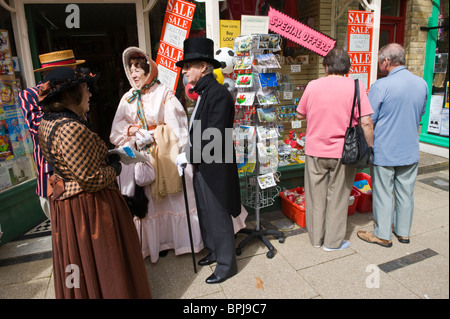 Frauen und Männer in historischen Kostümen vor modernen Geschäft auf dem jährlichen viktorianischen Festival in Llandrindod Wells Powys Mid Wales UK Stockfoto