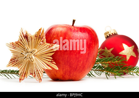 roter Apfel, ein Stroh Stern und eine rote Weihnachtskugel im Hintergrund mit einer Niederlassung auf weißem Hintergrund