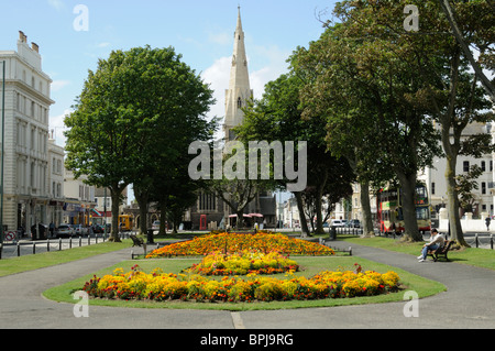 Blick auf die Kirche St. Johannes der Täufer durch die Bäume einen kleinen Park und Grünanlage in Hove, East Sussex, England. Stockfoto