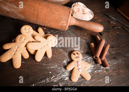 Rolling Pin und hausgemachte Lebkuchenmänner Kekse auf einem Holzbrett mit Mehl Stockfoto
