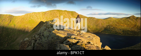 Walker auf der Grat des Schreitens Schmalkante in der Morgendämmerung im englischen Lake District. Lakelandpoeten im Hintergrund Stockfoto