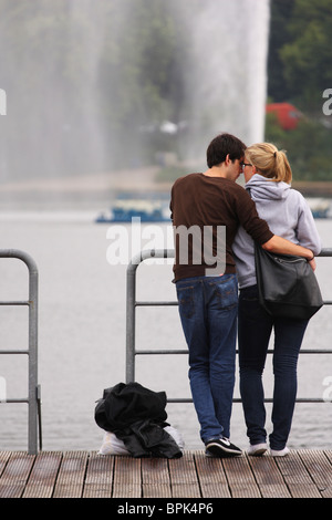 Junges Paar stehen zusammen am Rande der Alster in Hamburg Stockfoto