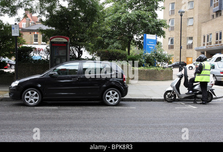 London Verkehrspolizist Ausstellung eines PCN auf ein Fahrzeug in Sydney Street, Chelsea, London. Stockfoto