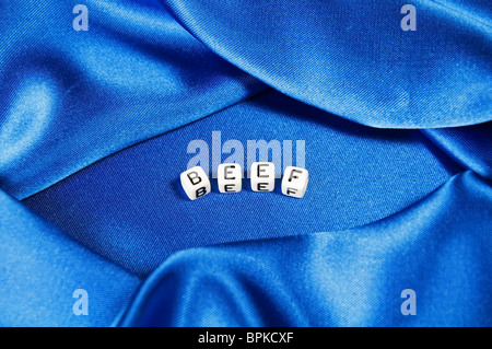 Royal Blue satin Hintergrund mit reichen Falten und Fältchen für Textur ist das Wort Fleisch in schwarz / weiß Cube Schriftzug Serie Stockfoto