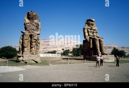 Die Kolosse von Memnon bewachen die Überreste von Pharao Amenhotep III Totentempel in der thebanischen Nekropole von Luxor in Ägypten. Stockfoto