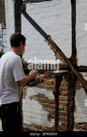 Renovierung einer alten Holz gerahmt denkmalgeschütztes Gebäude Arbeiter Ziegel entfernen & Rendern vor der Installation des neuen Eichenbalken Stockfoto