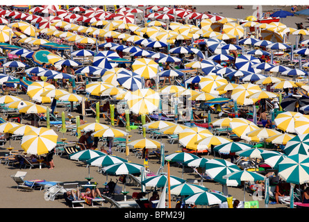 Massentourismus am Strand von Caorle, Adria, Italien. Tausende von Sonnenliegen und Sonnenschirme, Sonnenschirme. Stockfoto