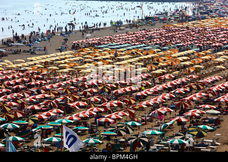 Massentourismus am Strand von Caorle, Adria, Italien. Tausende von Sonnenliegen und Sonnenschirme, Sonnenschirme. Stockfoto