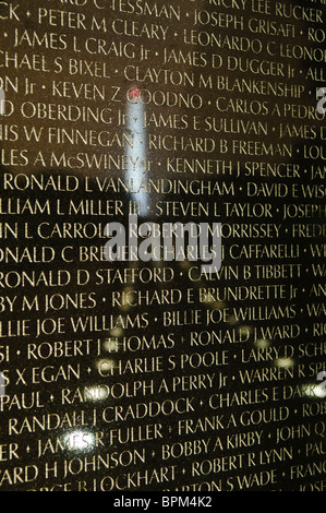 WASHINGTON DC, USA – die Mauer der Namen am Vietnam Veterans Memorial wird nachts beleuchtet, während das Washington Monument in der Ferne leuchtet. Die Gedenkstätte ehrt die Tausenden von Mitgliedern des amerikanischen Militärs, die im Vietnamkrieg ihr Leben verloren haben. Die reflektierende Mauer schafft eine feierliche und friedliche Nachtszene in der National Mall. Stockfoto