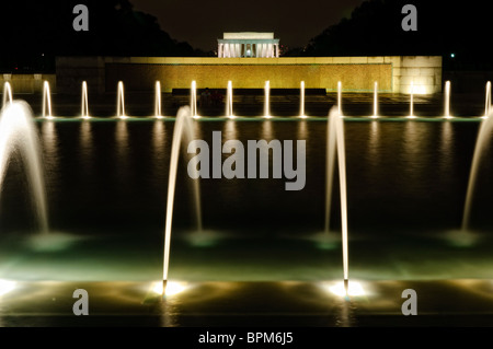 WASHINGTON DC, USA – der beleuchtete Brunnen des National World war II Memorial in der National Mall bei Nacht. Der Brunnen, ein zentrales Merkmal der Gedenkstätte, spiegelt sich wunderbar auf dem ruhigen Wasser wider und schafft eine ruhige und ergreifende Nachtszene, die diejenigen ehrt, die im Zweiten Weltkrieg dienten Stockfoto