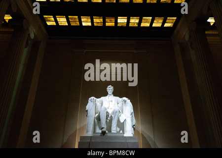 WASHINGTON DC, USA – die Statue von Abraham Lincoln im Lincoln Memorial bei Nacht. Die beleuchtete Statue des 16. Präsidenten der Vereinigten Staaten schafft eine feierliche und majestätische Atmosphäre innerhalb des Monuments in der National Mall. Die Statue, entworfen vom Bildhauer Daniel Chester French, ist ein zentrales Symbol der amerikanischen Geschichte und Demokratie. Stockfoto