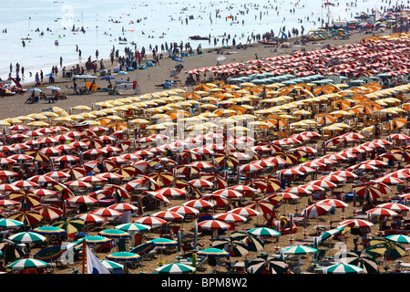 Massentourismus am Strand von Caorle, Adria, Italien. Tausende von Sonnenliegen und Sonnenschirme, Sonnenschirme. Stockfoto