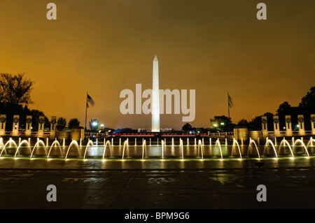 WASHINGTON DC, USA - Night Shot der Brunnen des National World War II Memorial mit dem Washington Monument in der Ferne. Stockfoto