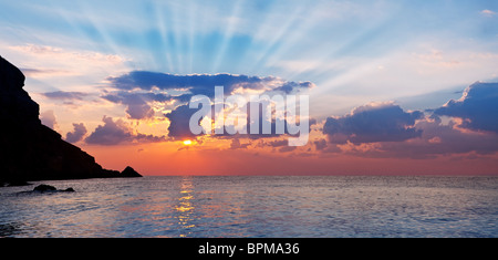 Wunderschöne Landschaft von der aufgehenden Sonne und Berge. Strahlen dringen in den Wolken. Stockfoto