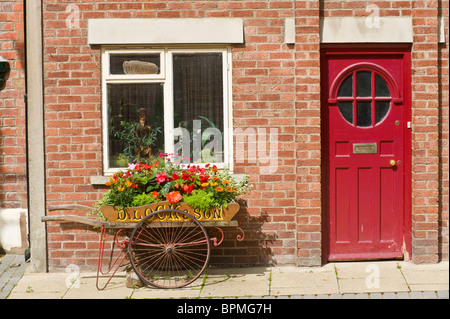 Rot lackierte Türfenster und Blume anzeigen in Barrow außerhalb gebaut Ziegelhaus in Llandrindod Wells Powys Mid Wales UK Stockfoto