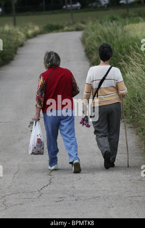 Zwei Frauen Blumenpflücken entlang einer Landstraße in Katalonien Spanien Stockfoto