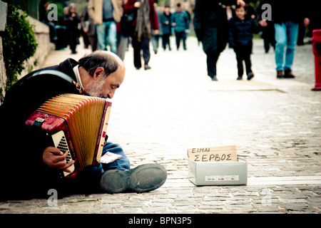 Alten serbischen Einwanderer um Geld zu spielen, auf den Straßen von Athen, Griechenland. Stockfoto