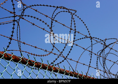 Stacheldraht, Stacheldraht und Ketteverbindung Zaun begrenzen Eintrag. Stockfoto