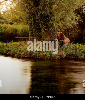 Ein Mann allein an einem Flussufer Angeln Stockfoto