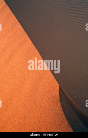 Licht- und Schattenspiel bei Sonnenaufgang über den Dünen von Erg Chebbi in der Nähe von Merzouga in Marokko Stockfoto