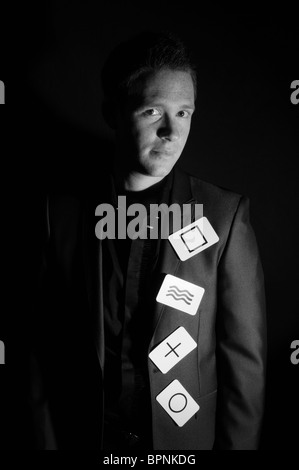 junge weiße männliche Zauberer mit Ingwer Haar posiert mit Symbol Spielkarten im studio Stockfoto