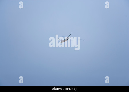 Ein Twin Rotor Hubschrauber fliegt über Kopf nach der Lieferung eines großen Sandsack auf Grand Isle in Louisiana Golfküste. Stockfoto