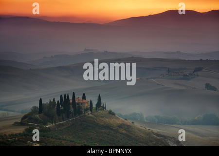 Klassische toskanische morgendliche Aussicht über einen nebligen Val D'Orcia in der Nähe von San Quirico in Italien Stockfoto