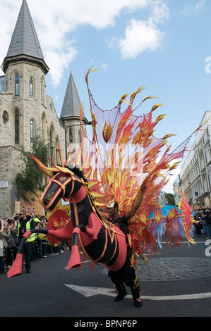 Afrikanische schwarzes Pferd gekleidet rot und männliche mit bunten Schmetterlingsflügel in Notting Hill Karneval 2010, London, England, UK Stockfoto