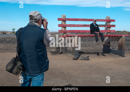 Ein Tourist versucht, eine riesige Parkbank in der New South Wales outback Bergbau Stadt Broken Hill Stockfoto