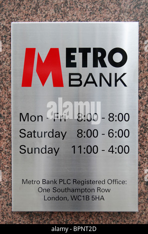 Walll Plaque zeigt Öffnungszeiten außerhalb der Metro-Bank in der ersten UK-Niederlassung in Holborn, London, UK. Stockfoto