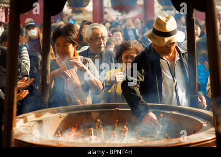Japanische Leute legen Räucherstäbchen in in Sensō-Ji buddhistischer Tempel in Asakusa, Tokio, Japan. Stockfoto