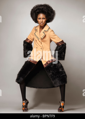 Lizenz erhältlich unter MaximImages.com High Fashion Foto von einer jungen Frau, die einen Mantel mit schwarzem Fell trägt Stockfoto