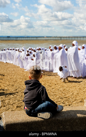 Ein Junge beobachten Mitglieder der Apostel des Muchinjikwa Kirche beten auf Jubiläum Strand in Southend. Stockfoto