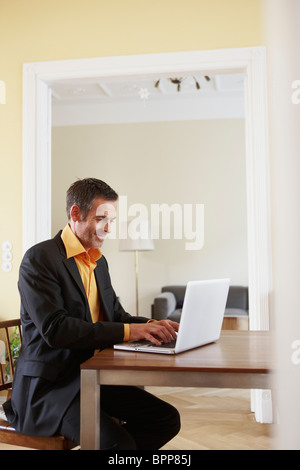 Mann am Laptop tippen Stockfoto