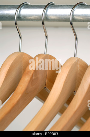 Hölzerne Kleiderbügel hängen an einer Metallschiene Stockfoto