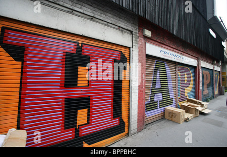 Eine Straße-Kunstwerk des Künstlers Ben Eine, zeigt das Wort "HAPPY" Ben ist einer der bekanntesten Namen in der Kunstszene UK Street. Stockfoto