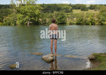 Frau stehend auf Felsvorsprung im Fluss Stockfoto