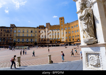 Italien Toskana Siena religiöse Schnitzen auf Eingang Portikus der gotische Palazzo Publico Rathaus mit Touristen in Piazza del Campo Stockfoto