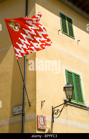 Italien Toskana San Quirico d ' Orcia rote und weiße Fahne des Castello Viertel auf der Ecke des Gebäudes während Barbarossa Festival. Stockfoto